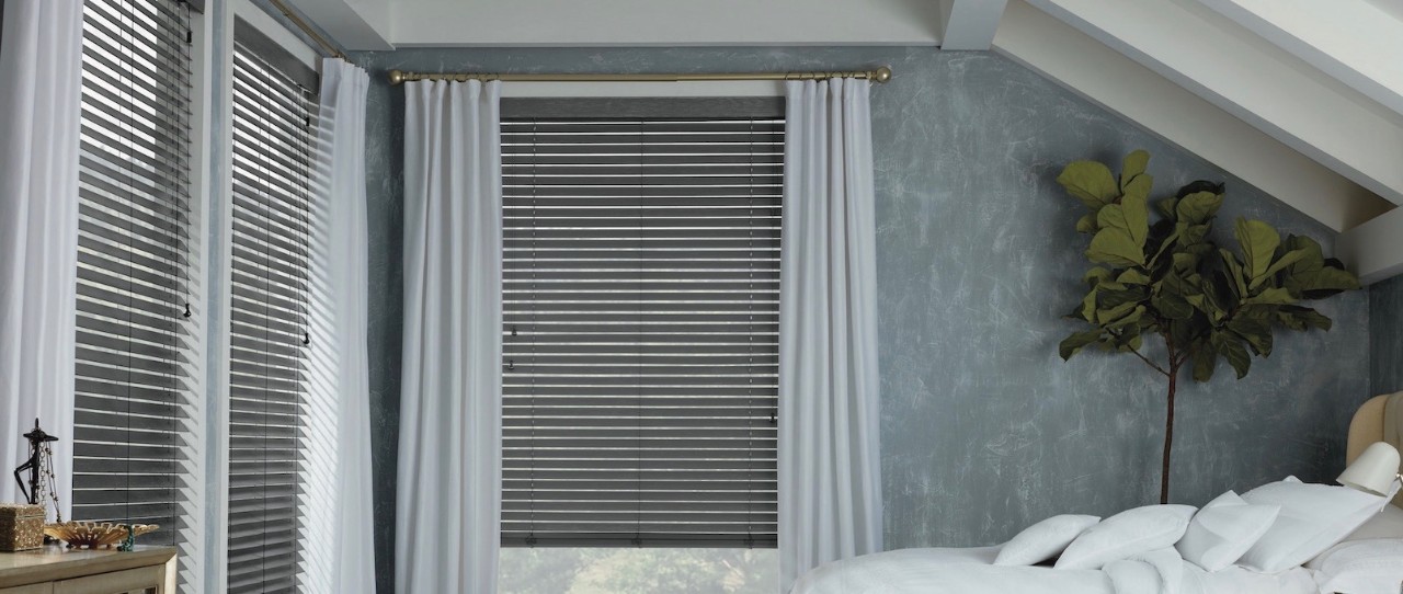 Bedroom with grey walls, long white curtains and metal blinds